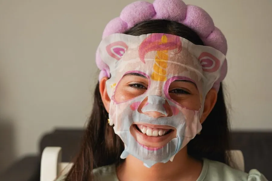 A kid wearing a sheet mask that looks like an animal.